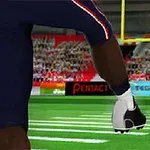 Un jucător de fotbal american lovește o minge ovală pe un teren în fața tribunelor pline cu spectatori