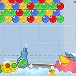 Rațe colorate se joacă într-o cadă cu baloane colorate agățate deasupra și un felinar în partea dreaptă