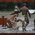 Jucători de rugby murdari de noroi se luptă pentru minge pe un teren noroios, cu un efect de piesă de puzzle evidențiată în imagine